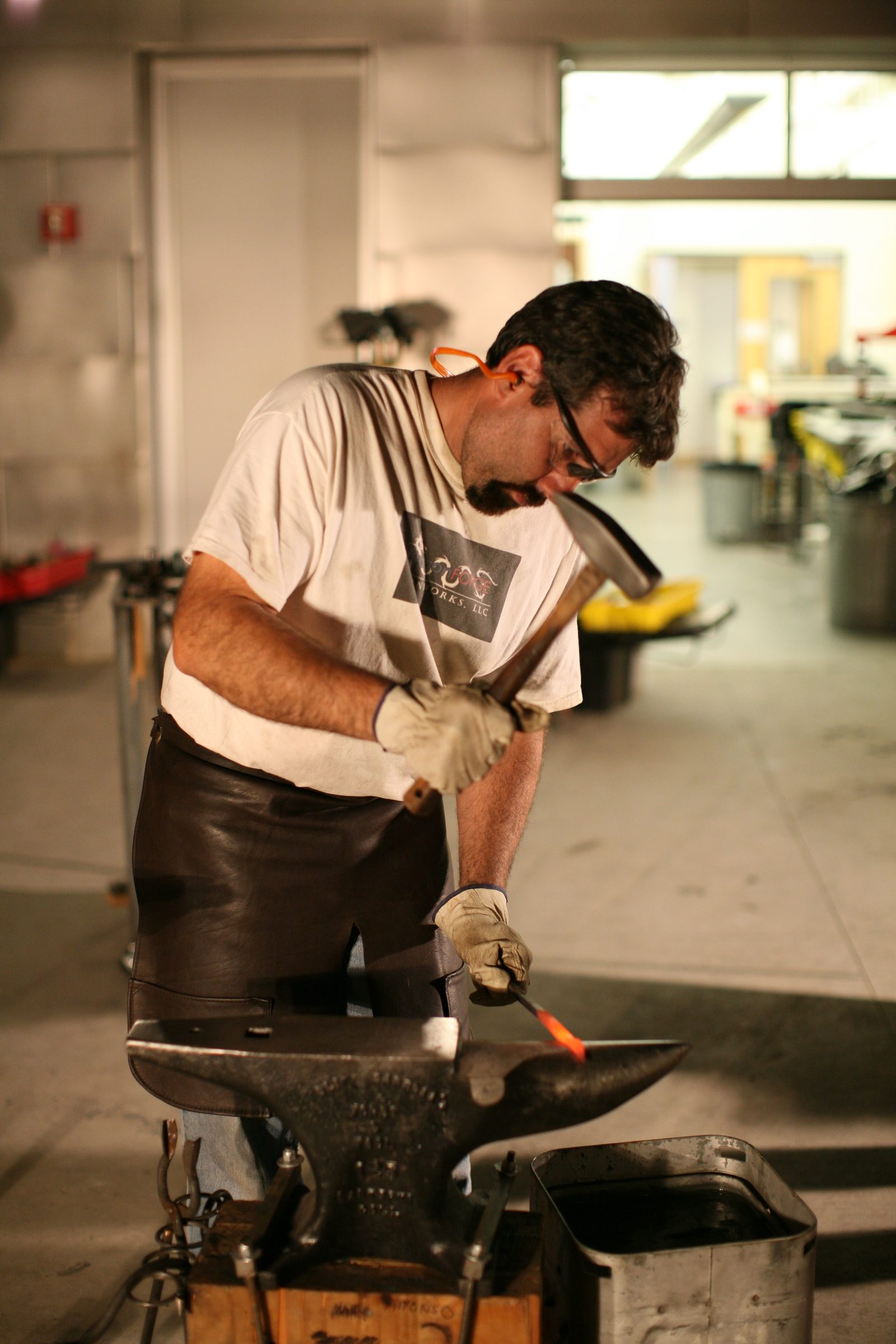 Michael shaping hot iron on the anvil.