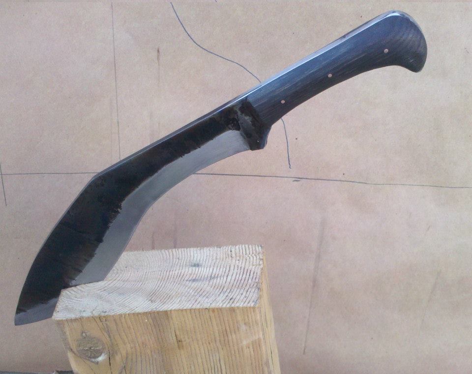 Heavy curved cleaver with dark hardwood handle and copper rivets.