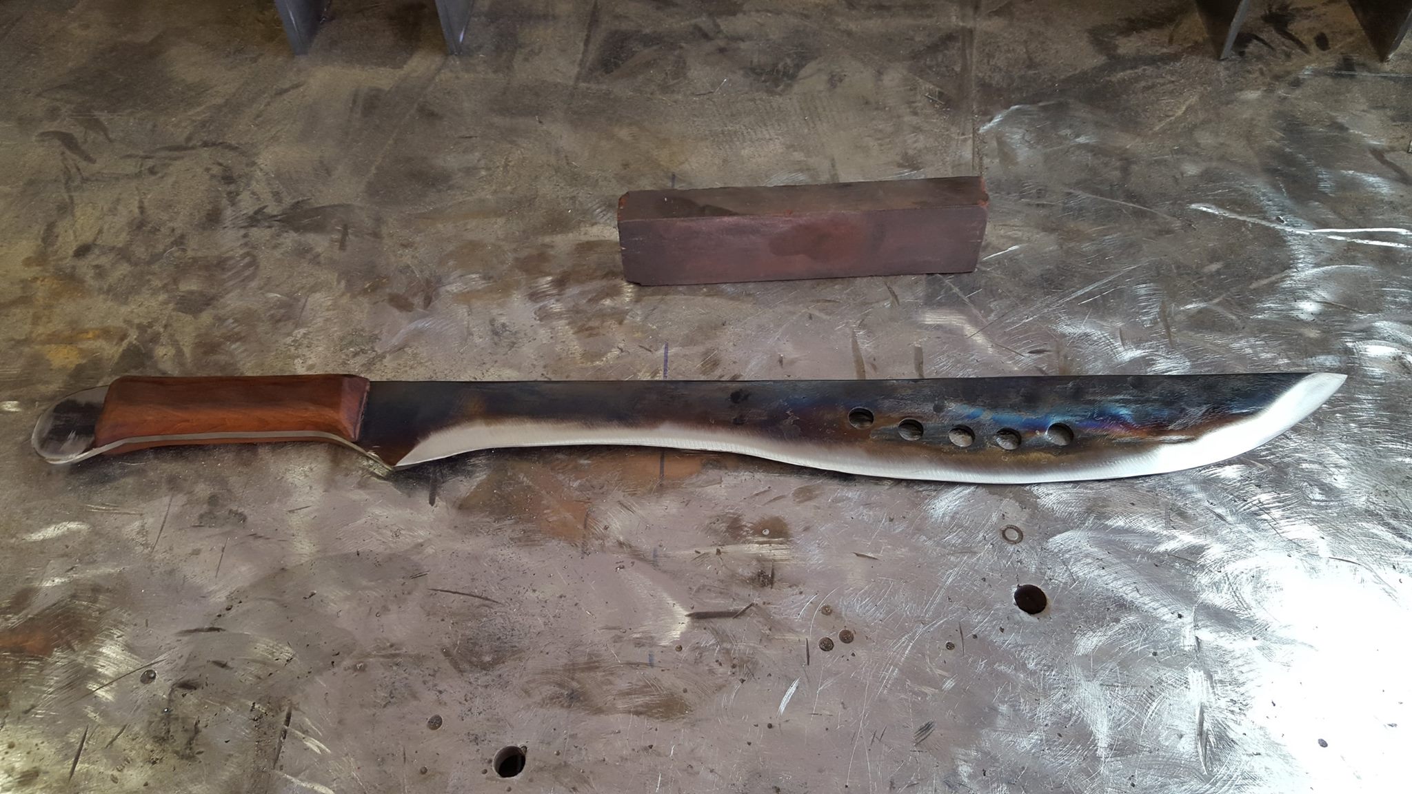 Long bush-chopper blade with heat-tinted finish and walnut handle.