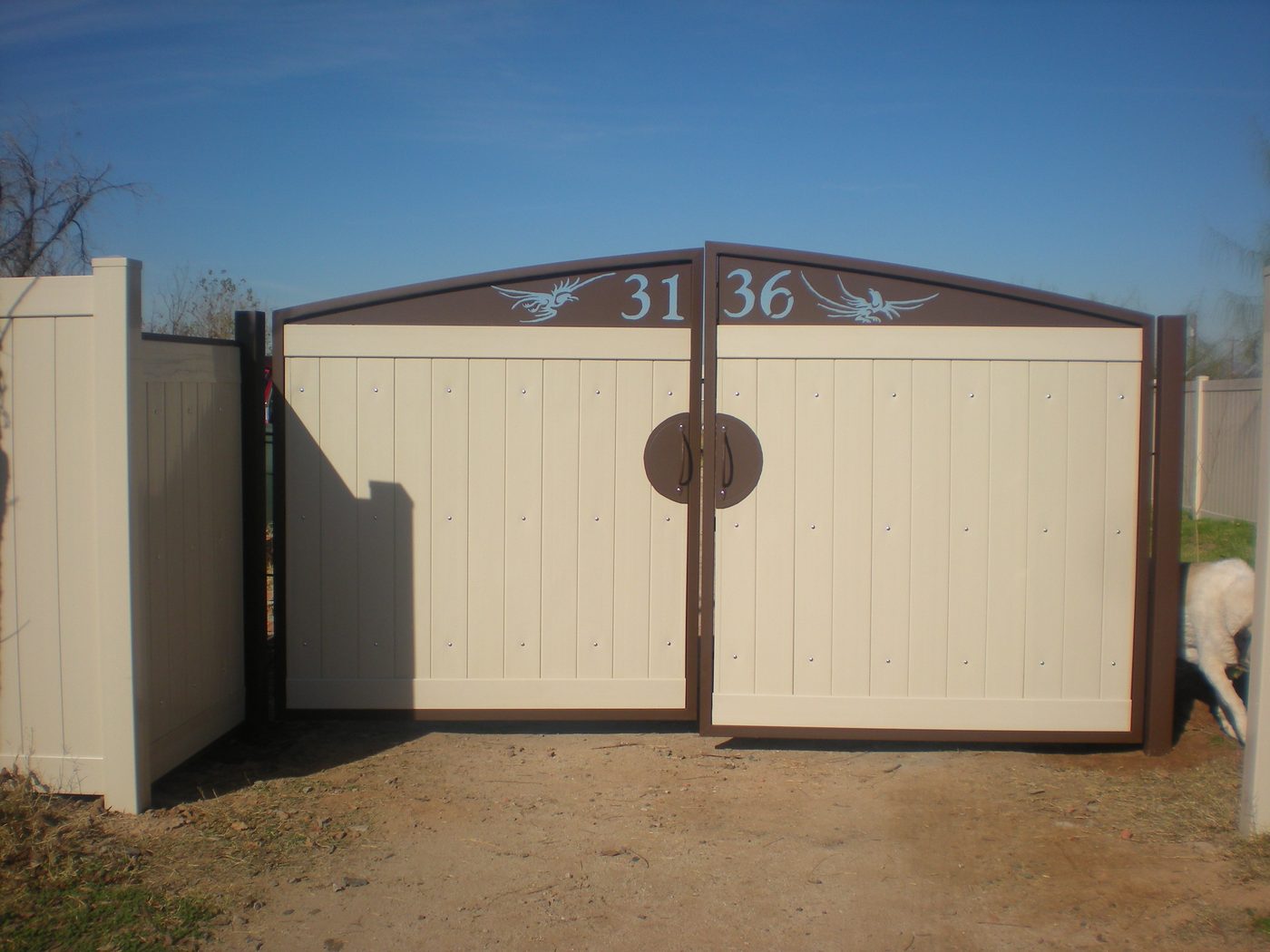Custom drive gate with dragon silhouettes and brass house numbers.